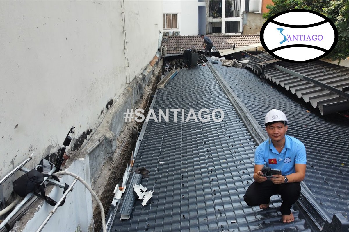 Mái ngói nhựa xám chạy dọc giữa hai bức tường nhà phố