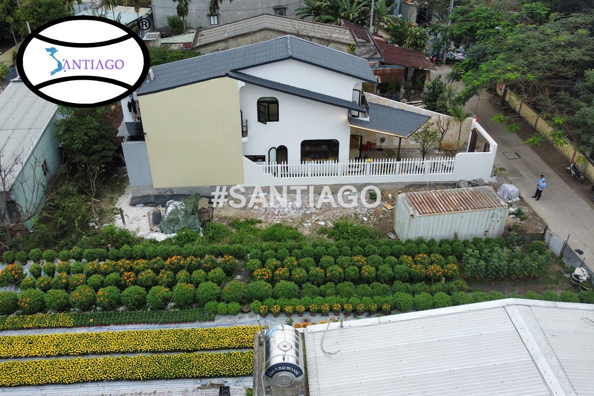 Nhà lợp ngói nhựa xám giữa vườn hoa