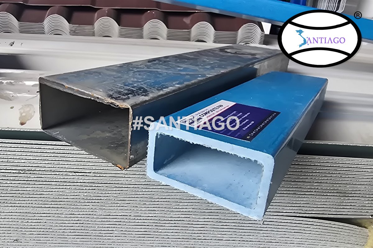 Thanh thép hộp đã rỉ đặt cạnh xà gồ composite xanh có nhãn Santiago FRP