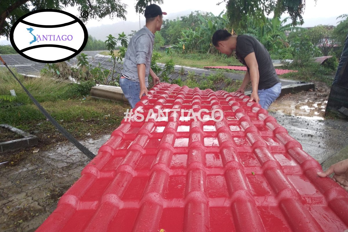 Thợ nâng tấm ngói nhựa đỏ dài lên mái quán cà phê ở Đà Nẵng